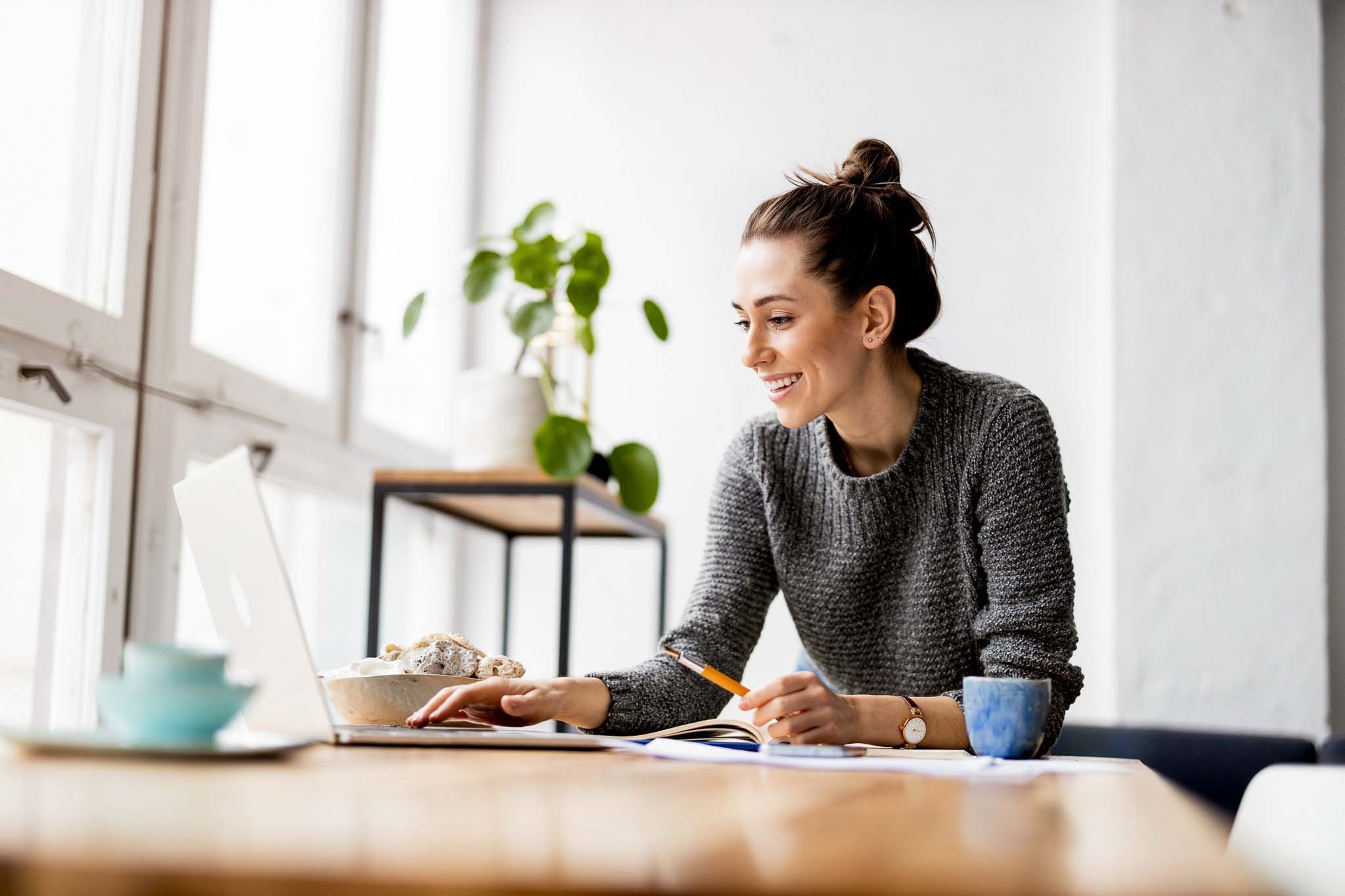 Creative young woman working on laptop in her studio