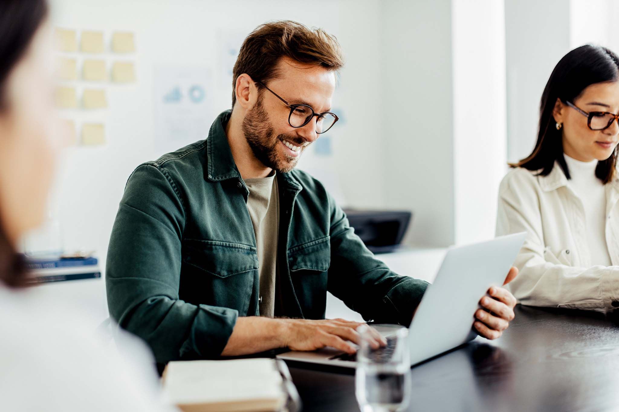 Designer using a laptop while sitting in a meeting